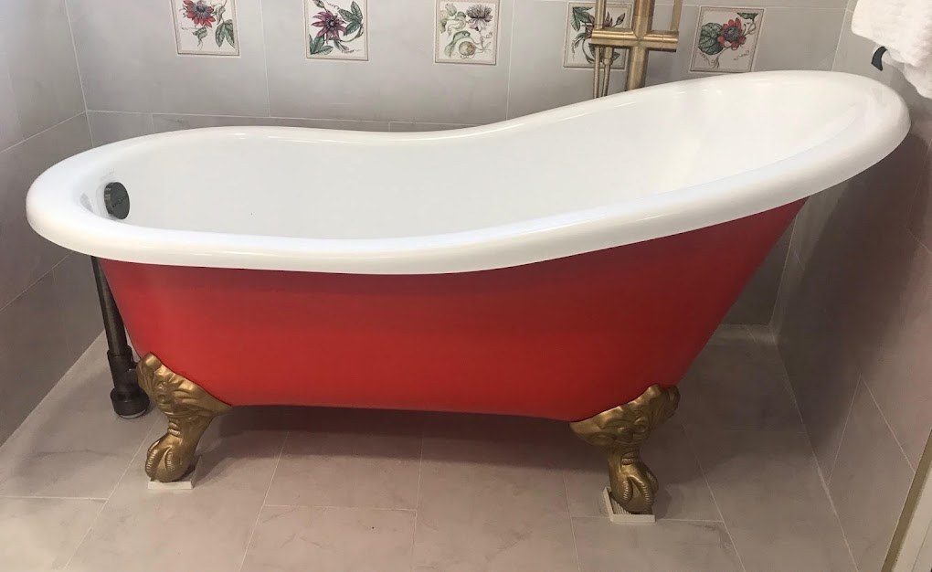 Clawfoot tub refinished with a red exterior and gold feet