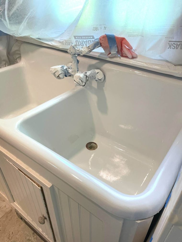 The same farmhouse sink after refinishing, in a smooth, glossy white