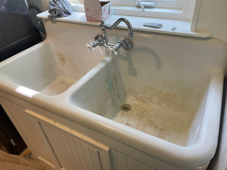 Stained, worn cast-iron double farmhouse sink before refinishing
