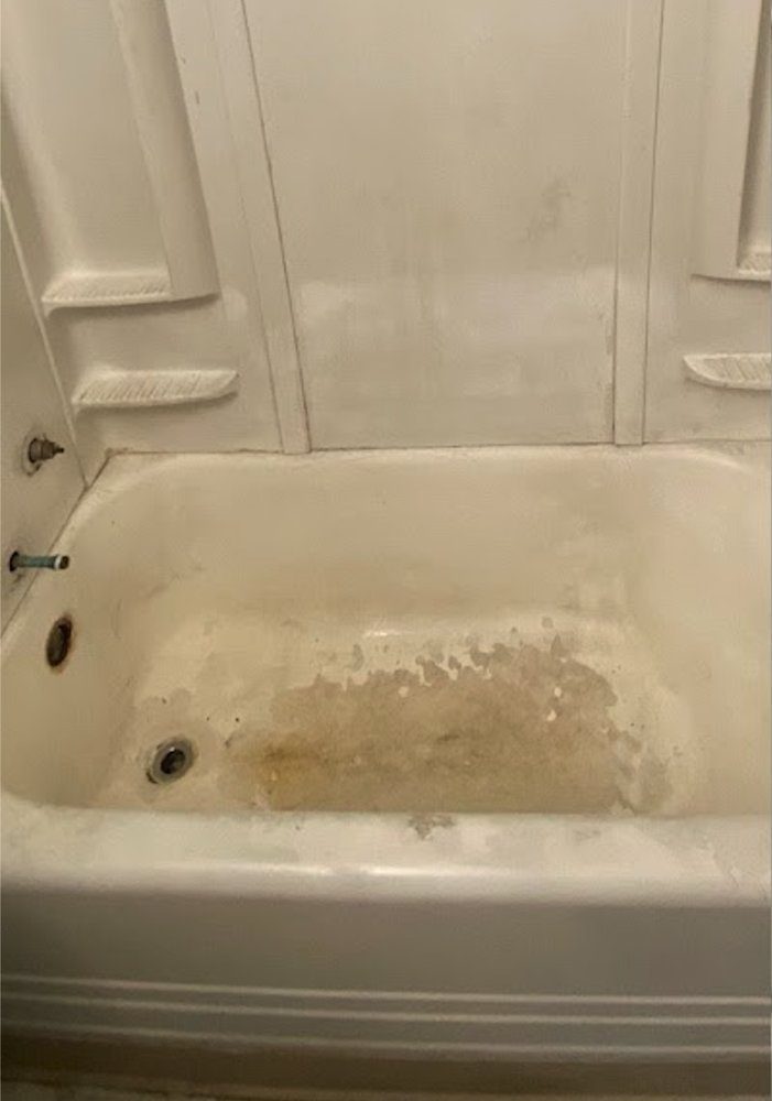Stained, worn bathtub and tile surround before refinishing