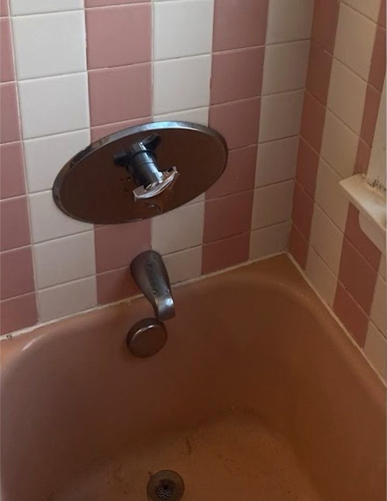 Dated pink bathtub and wall tile before refinishing